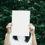 young woman holding a blank sheet of white paper in front of her face - children of addicts