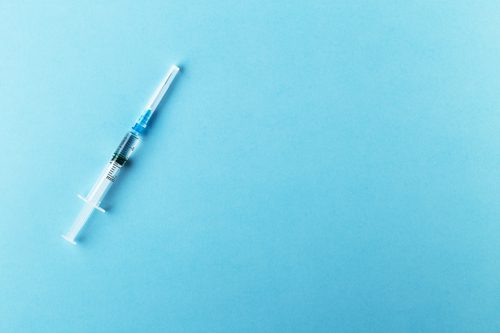 syringe on blue background - IV