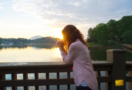 woman praying on bridge - spirituality and recovery