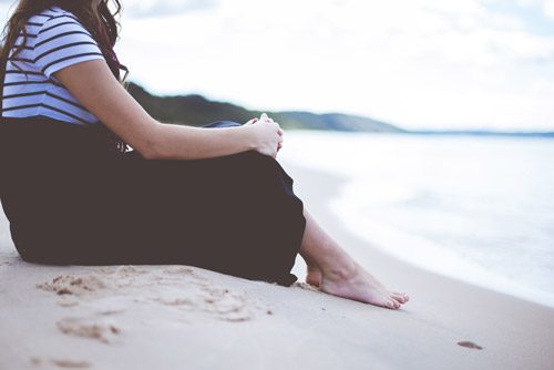 woman sitting on beach - emotional sobriety