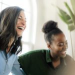 small group of women friends smiling and laughing together indoors - social support