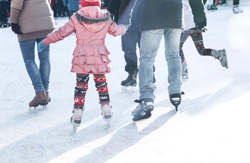 cropped shot of family of three ice skating outdoors at a rink - sobriety