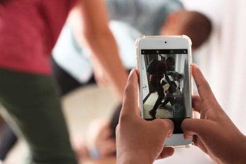 older grade school kids bullying another student while someone records it on their phone - Childhood Trauma and Adult Addiction