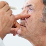 Elderly man examined by an ophthalmologist stock photo - alcoholism and eye health