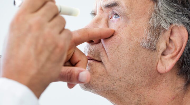 Elderly man examined by an ophthalmologist stock photo - alcoholism and eye health